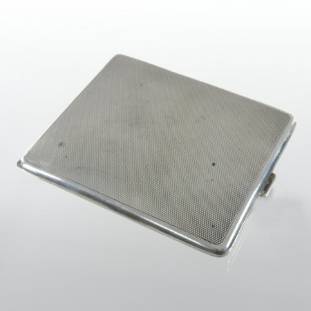 An Edwardian silver cigarette case, of hinged rectangular shape, with engine turned decoration,