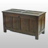 An 18th century oak coffer, of panelled construction, with a hinged lid,