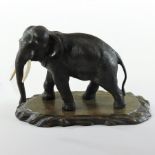 A Japanese bronze model of an elephant, Meiji period, on a carved rosewood plinth base,