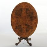 A Victorian walnut and inlaid loo table, of oval shape, on a carved quadruped base,