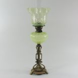 An Arts and Crafts brass oil lamp, with a green opaline glass shade,