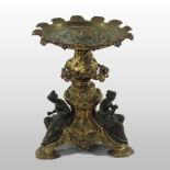 A 19th century ormolu and silvered bronze centrepiece, with figural supports, on a sculpted base,