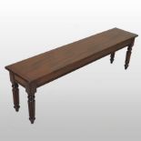 A Regency style mahogany window seat, having a solid seat, on reeded legs,