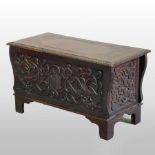 A mid 20th century carved oak coffer, with a hinged lid,