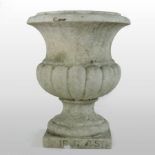 A carved white marble garden urn, the half gadrooned body, on a socle plinth base,