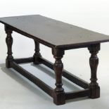 An 18th century style oak refectory table, having a plank top, on turned legs,