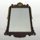 A George III style mahogany and parcel gilt fret carved wall mirror, within a scrolled surround,