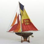 An early 20th century wooden pond yacht, with sails and rigging,