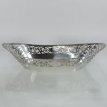 An early 20th century silver sweetmeat basket, of oval shape, with a pierced scrolled frieze,