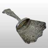 An ornate George III silver sugar spoon, of shovel shape, with a shell terminal, London 1797,
