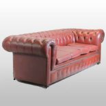 A Victorian style red upholstered button back three seater Chesterfield sofa,