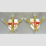 A pair of wall lights, in the form of heraldic shields and torches,
