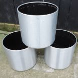 A set of three silver coloured garden pots,