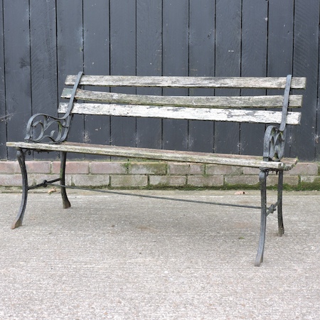 A slatted wooden garden bench, with metal ends,