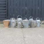 A collection of galvanised watering cans and buckets