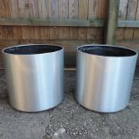 A pair of brushed aluminium effect garden pots,