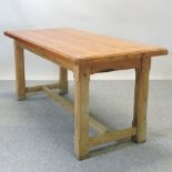 A pitch pine kitchen table, on square legs with a stretcher base,