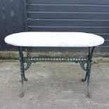 A green painted metal garden table with a marble top,