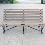 A large black painted iron and slatted hardwood garden bench,