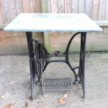 A black painted metal and marble garden table,