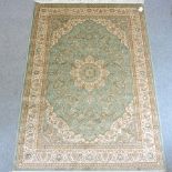 A Keshan style rug, with a central medallion and foliate design, on a green ground,