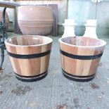 A pair of wooden half barrel planters,