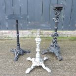 A Victorian cast iron table base, together with two others,