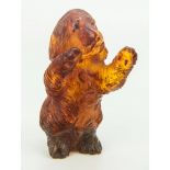 A miniature carved amber model of a spaniel, stood upright begging on hind legs, with inserted black