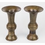 A pair of Japanese bronze Gu form vases, c.1900, base with impressed floral motifs below banded