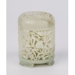 A Chinese pierced and carved pale celadon jade pot and cover, of cylindrical form, raised on three