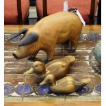 A carved wooden pig with two ducks, pig 9.5in. (24.2cm.) high.