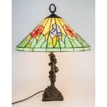 A Tiffany style lampshade on Art Nouveau style figural base, 24in. (61cm.) high, 19in. (48.2cm.)