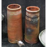 Two tall terracotta chimney pots, both with painted white wave design, the taller one with applied