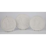 A set of three Royal Copenhagen parian plaques, circular form bearing classical scenes in relief,