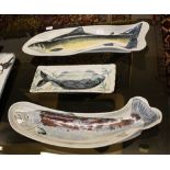 Three highland stoneware fish platters, two of piscean form, one rectangular, longest 25in. (63.