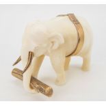 A miniature 9ct gold and ivory carved elephant, modelled as a working elephant carrying a gold log