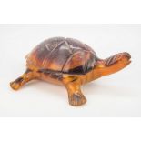 A carved tortoise shell model of a tortoise, 3in. (7.6cm.) long.,