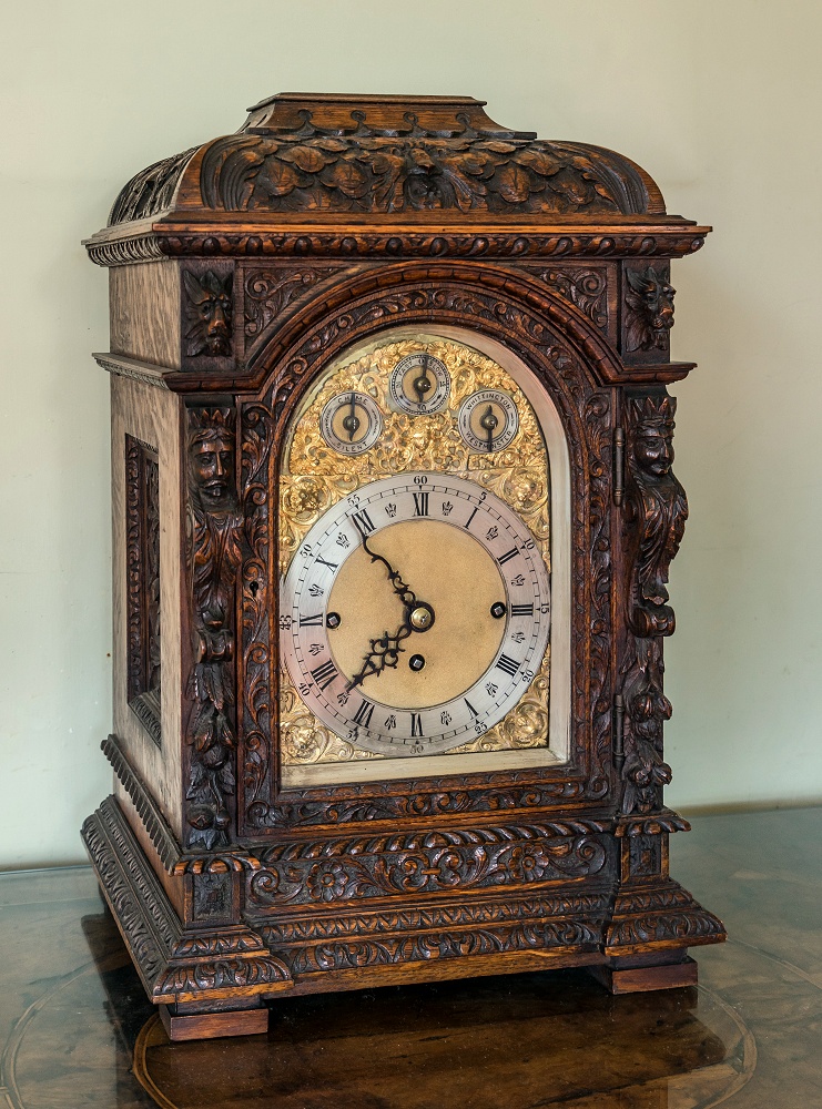 An impressive Victorian carved oak chairman's or boardroom quarter chiming triple fusee bracket