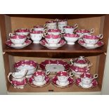 An early 19th century Rockingham style part tea service, crimson and white with gilt highlights,