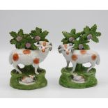 A pair of Ralph Salt porcelaneous Staffordshire rams, 19th century, standing beside a tree on