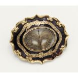 A Victorian gold and enamel mourning brooch, oval lentical with lock of hair in fanned design,