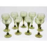 A set of nine green blown glass wine glasses, Continental, early 20th century, the cup bowls with