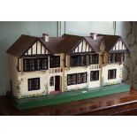 A Triang 'Stockbrokers' Tudor style dolls house, 1930s, thatched and timber triple apex roof, three