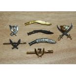 A collection of Gurkha interest pin badges / brooches, including a silver kukri with removable