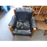 A vintage Arts & Crafts Morris style leather covered hardwood armchair with button decoration,