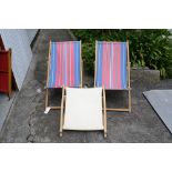 Two vintage deck chairs with original stripped canvas, one with foot rest.