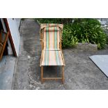 A vintage steamer lounger sun bed deck chair with foot rest & shade cover, original striped canvas.