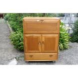 A light elm fall front Ercol bureau,with fitted interior.