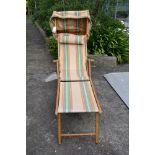 A vintage steamer lounger sun bed deck chair with foot rest & shade cover, original striped canvas.