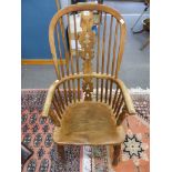 An antique oak stick back Windsor elbow chair.